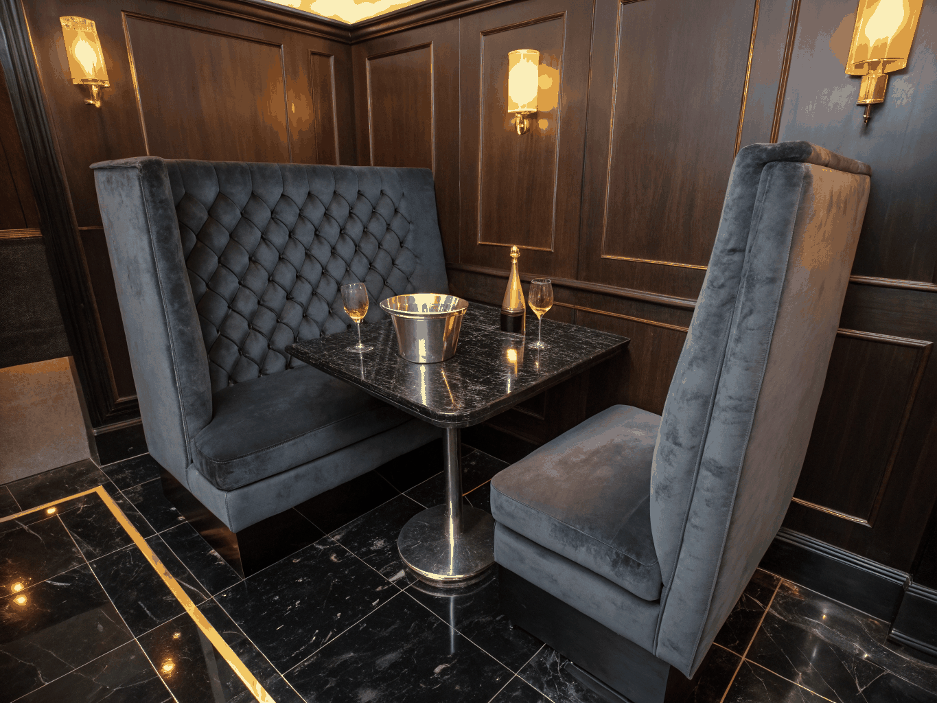 Intimate velvet dining booth under warm brick archways